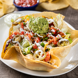taco salad: Ground beef or chicken tinga on a crisp blend of lettuce & shredded cabbage, mixed cheese, guacamole, lime crema, pico de gallo and pickled jalapeños. Served in a crisply tortilla shell.