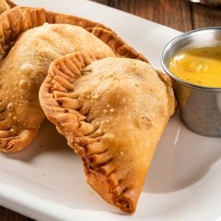 Empanadas: Two handmade pastries filled with mixed cheese & chicken tinga or seasoned ground beef. Served with our signature queso.